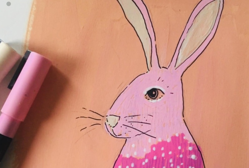 A pink hare on colored paper