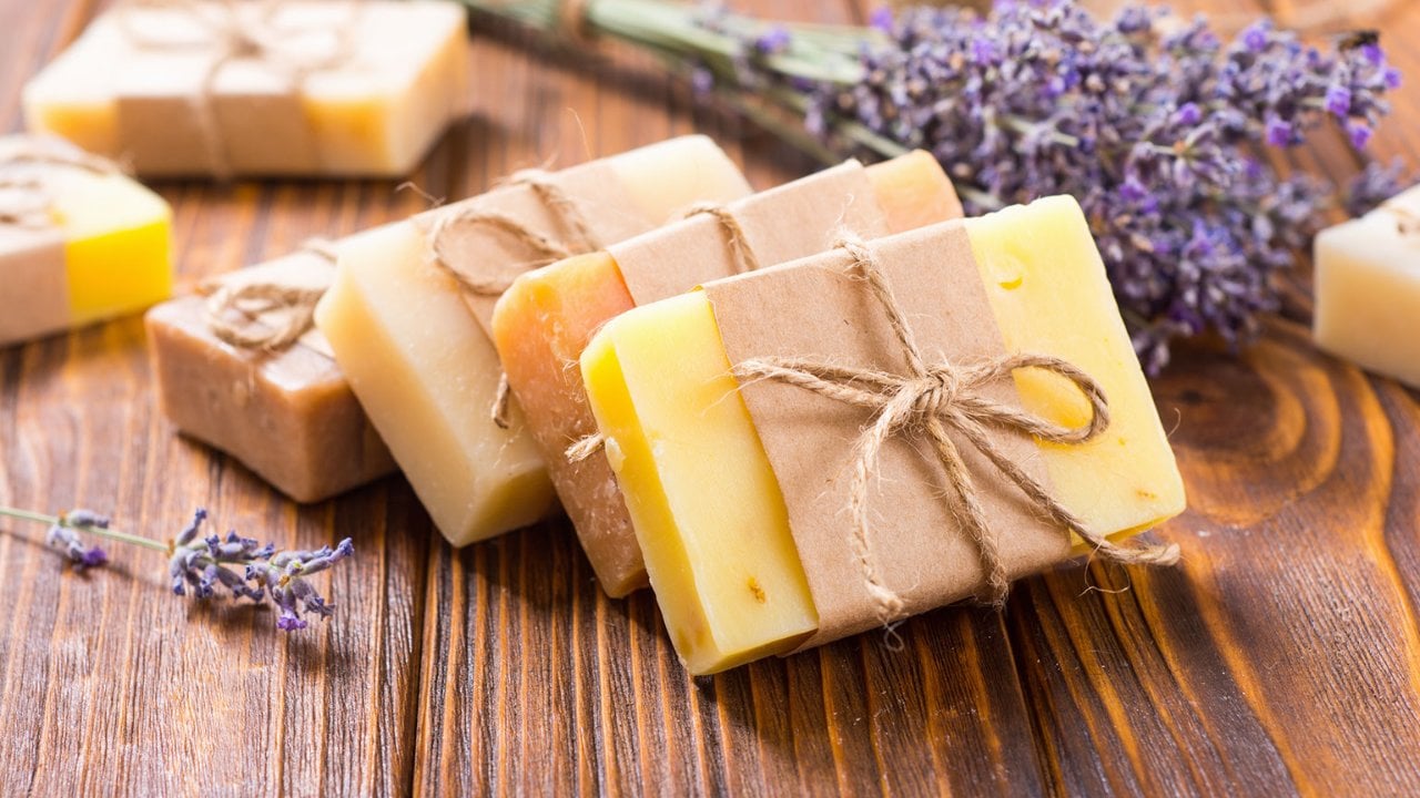 Making soap from pour and melt soap base concept. Soap making ingredients  on brown wooden background. melt and pour method, buy a soap base that's  already been made and cured. Stock Photo